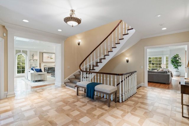 a view of staircase with furniture and a chandelier
