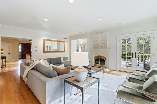 a living room with furniture a fireplace and a floor to ceiling window