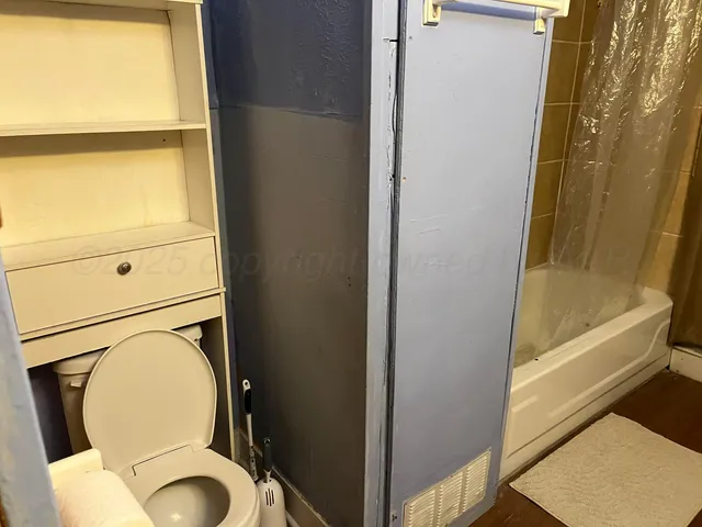 a bathroom with a toilet and a tub