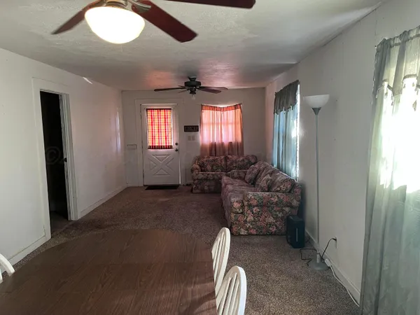 a living room with furniture windows and a chandelier