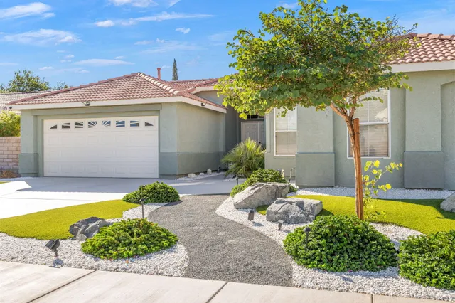 a front view of a house with a garden