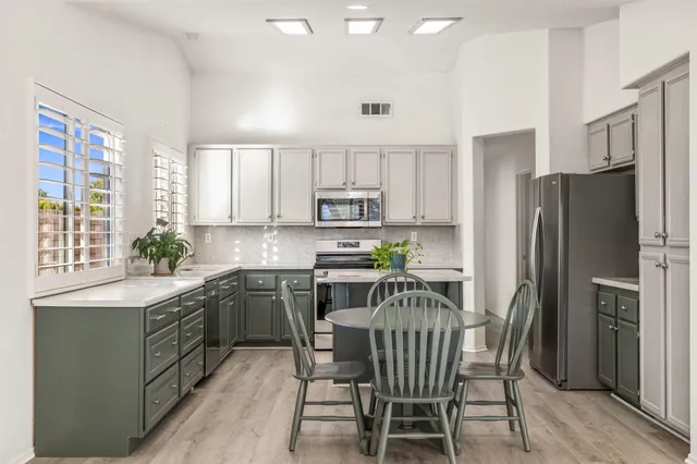a kitchen with a table chairs refrigerator and microwave