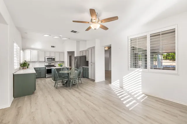 a kitchen with a dining table chairs appliances and cabinets