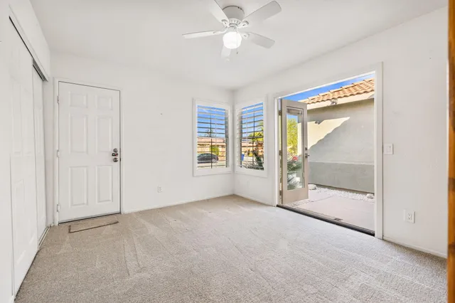 a view of an empty room with a window and wooden shelves