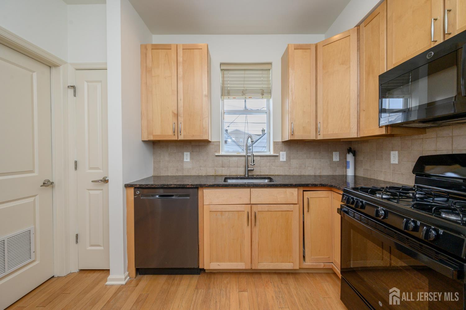 361 Lehigh Avenue Perth Amboy, NJ 08861 - Photo 9 of 28 a kitchen with stainless steel appliances granite countertop a stove a sink and a microwave