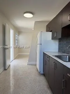 a kitchen with refrigerator and cabinets