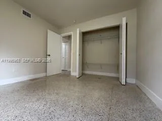 an empty room with closet and windows
