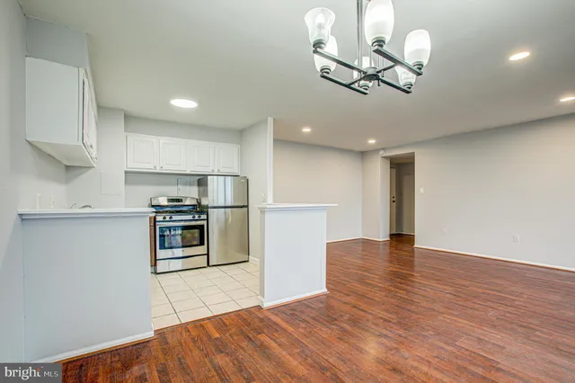 a kitchen with stainless steel appliances granite countertop a refrigerator a stove and a wooden floors