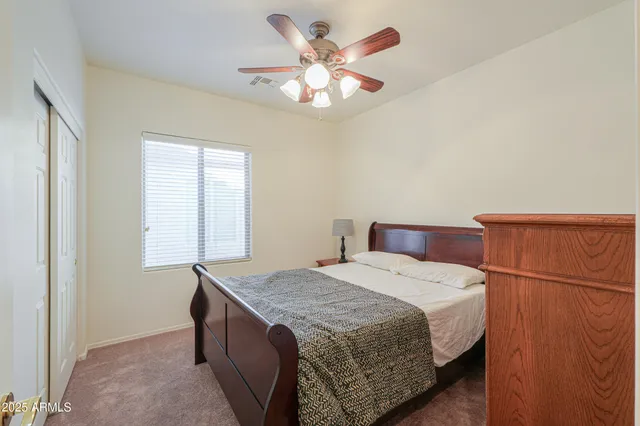 a spacious bedroom with a bed and a chandelier