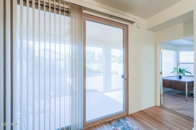 a view of a hallway with wooden floor and a bedroom