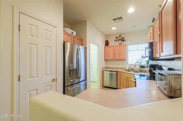 a kitchen with stainless steel appliances granite countertop a refrigerator sink and stove
