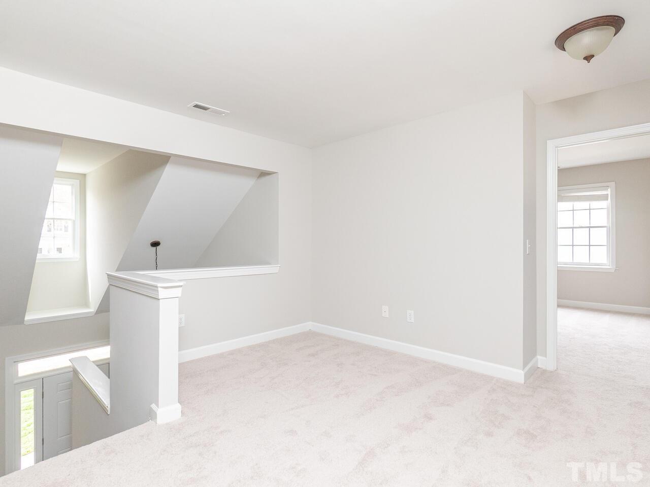 7916 Milltrace Run Raleigh, NC 27615 - Photo 22 of 28 a view of an empty room with wooden floor and a window