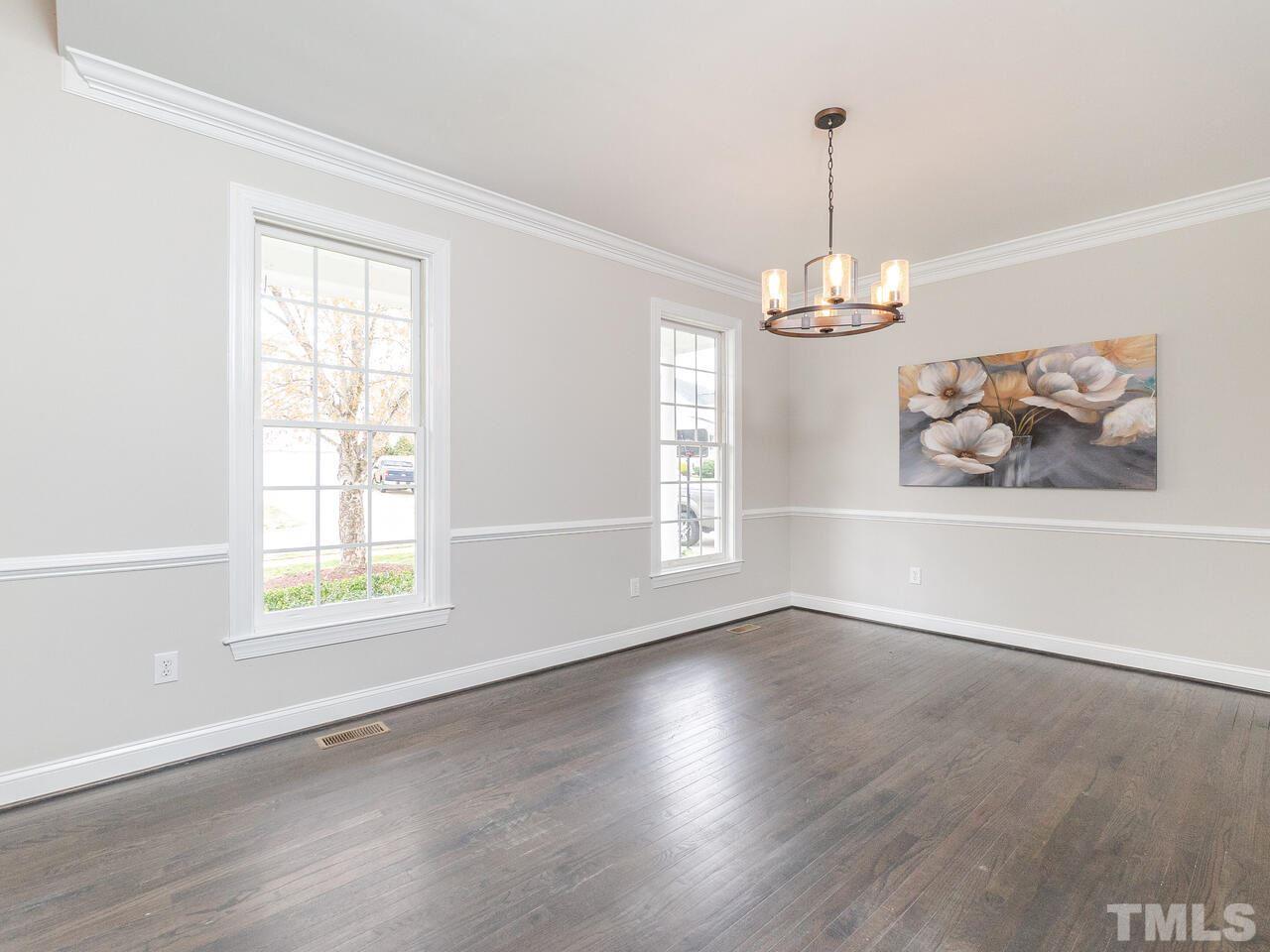 7916 Milltrace Run Raleigh, NC 27615 - Photo 4 of 28 an empty room with wooden floor windows and wall