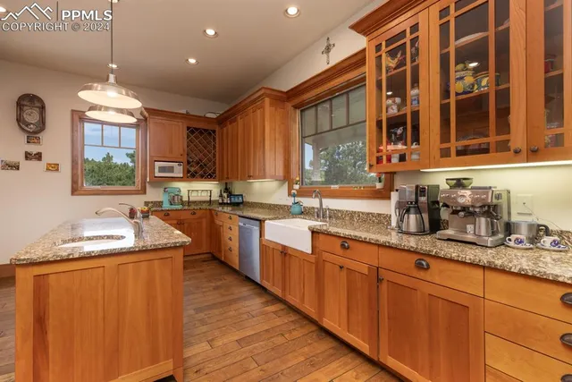 a kitchen with stainless steel appliances granite countertop wooden cabinets a sink and dishwasher