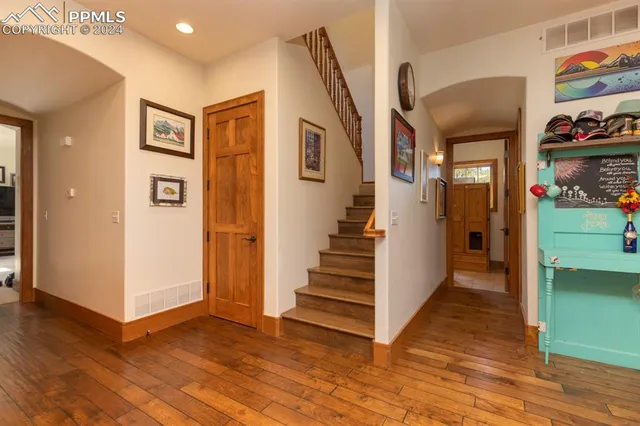 a view of a hallway with wooden floor and entryway