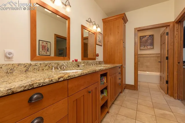 a spacious bathroom with a granite countertop sink and a mirror