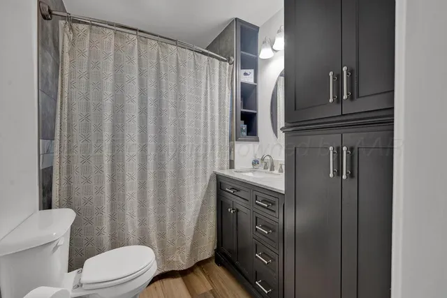 a bathroom with a granite countertop sink toilet and shower