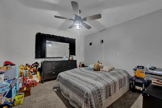 a bedroom with a bed and a flat tv screen on the dresser