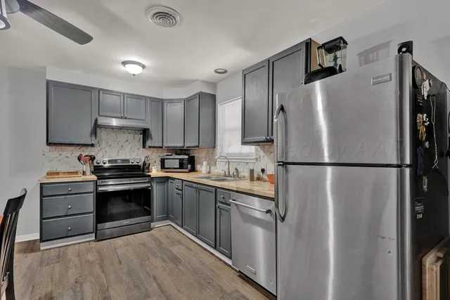 a kitchen with stainless steel appliances granite countertop a refrigerator sink and stove