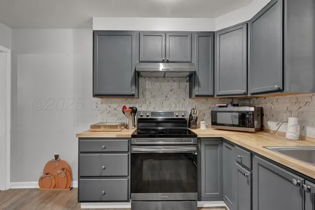 a kitchen with a sink stove and cabinets