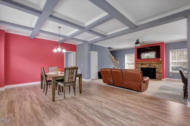 a living room with furniture a fireplace and a dining table with wooden floor