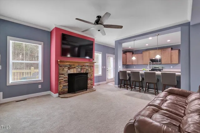 a living room with furniture a fireplace and a kitchen