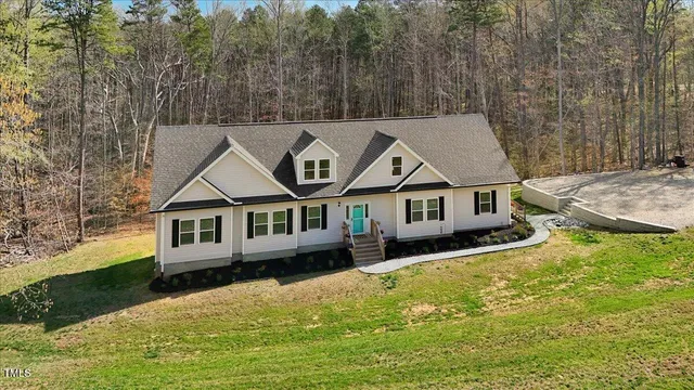 an aerial view of a house with swimming pool and a yard