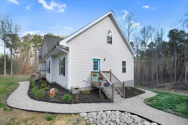 a view of a white house with a yard and potted plants
