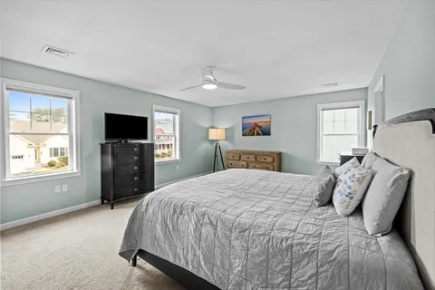 a bed room with a bed television and a window