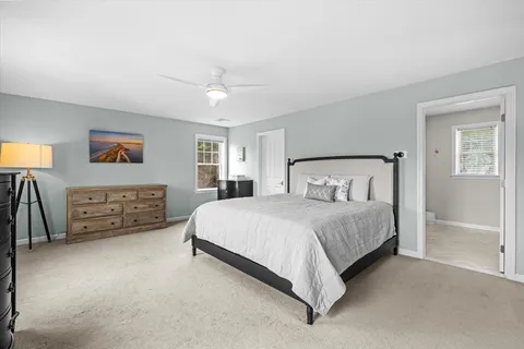a spacious bedroom with a bed a couch and a flat screen tv