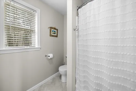 a bathroom with a toilet and a shower