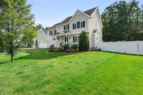 a front view of a house with a garden and trees