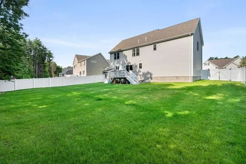 a view of a house with a big yard and large trees