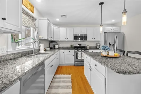 a large kitchen with stainless steel appliances granite countertop a sink a stove and a granite counter tops