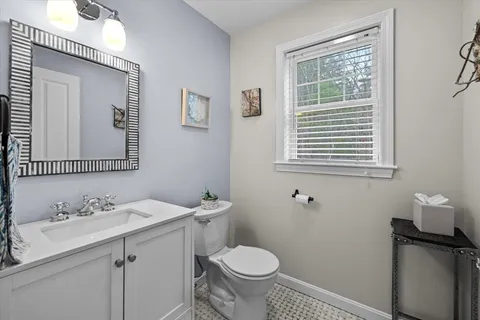 a bathroom with a granite countertop toilet sink and mirror