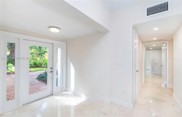 a view of a big room with windows and entryway
