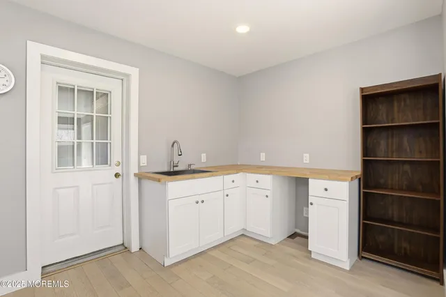 a room with a sink cabinets and a window