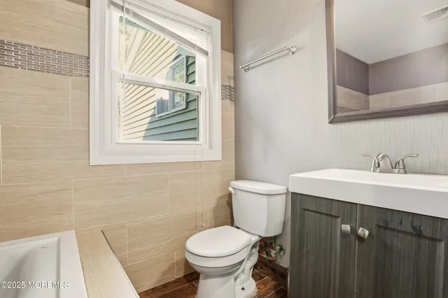 a bathroom with a toilet sink and a mirror