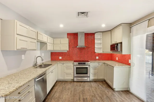 a kitchen with stainless steel appliances granite countertop a sink stove and refrigerator
