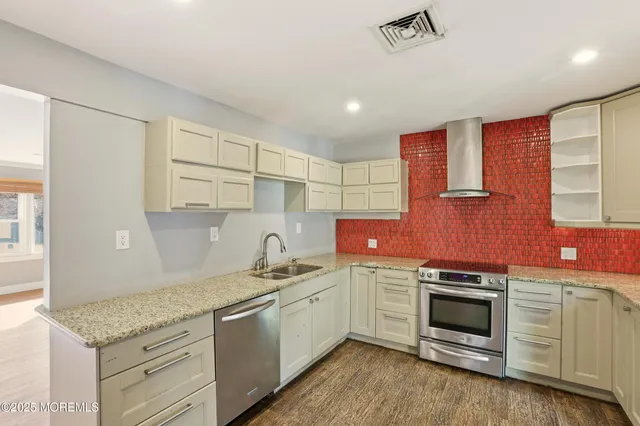 a kitchen with stainless steel appliances granite countertop a sink and cabinets