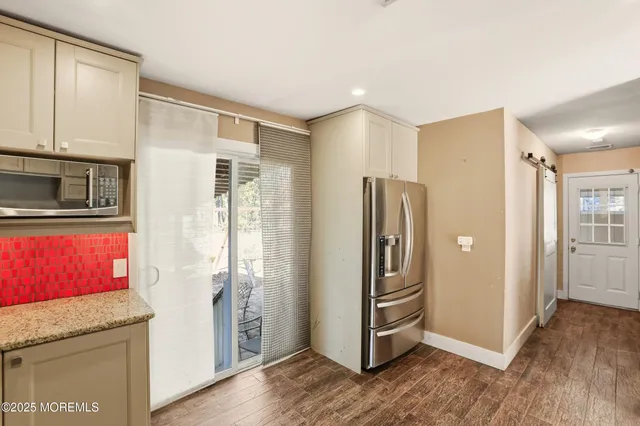 a view of a kitchen with wooden floor and electronic appliances