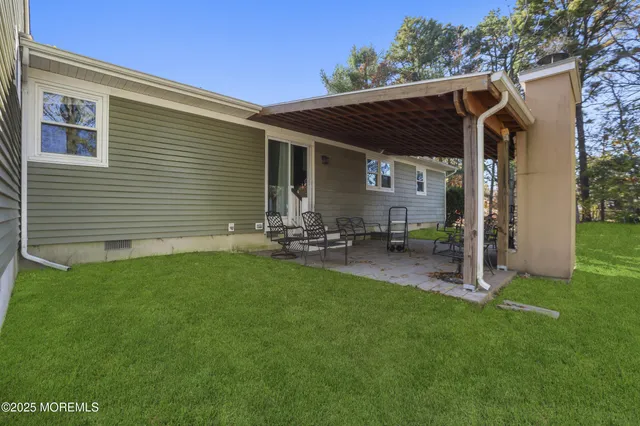 a view of a backyard with table and chairs with wooden fence