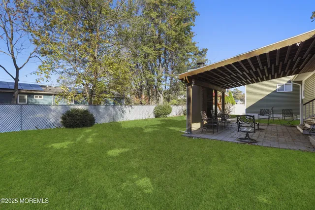 a view of a backyard with table and chairs under an umbrella