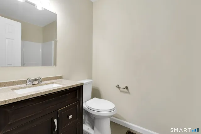a bathroom with a sink a toilet and a mirror