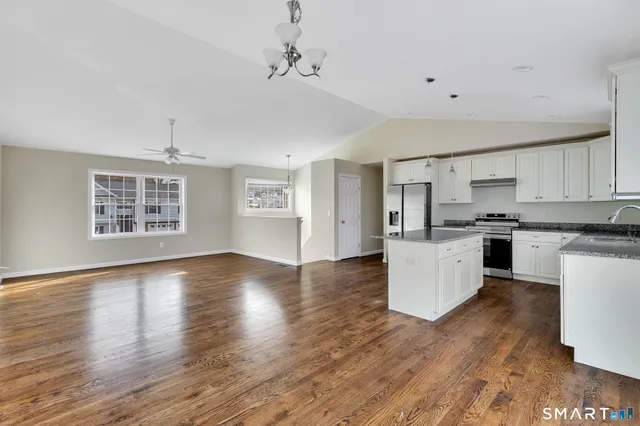 a kitchen with wooden floors and white cabinets
