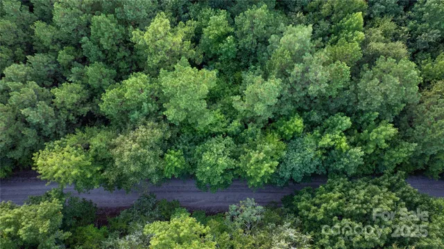an aerial view of residential house with outdoor space and trees all around