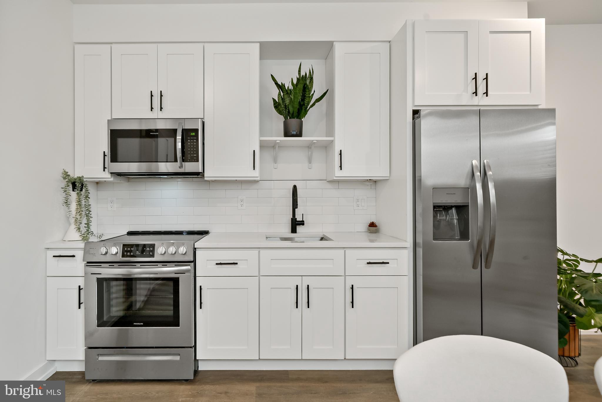 3845 North Broad Street, Unit 3F Philadelphia, PA 19140 - Photo 3 of 19 a kitchen with cabinets stainless steel appliances and wooden floor