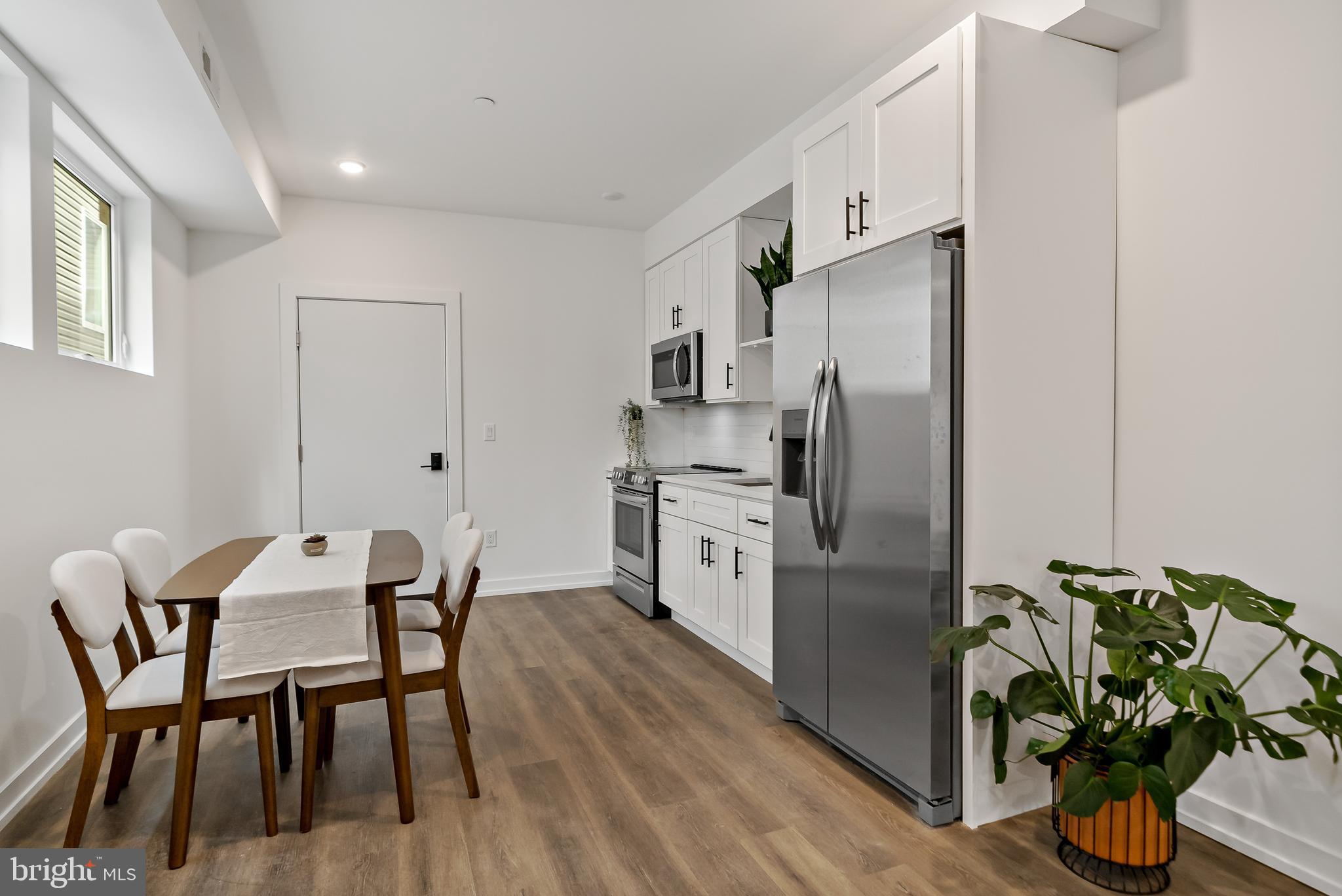 3845 North Broad Street, Unit 3F Philadelphia, PA 19140 - Photo 5 of 19 a kitchen with stainless steel appliances a dining table chairs and wooden floor