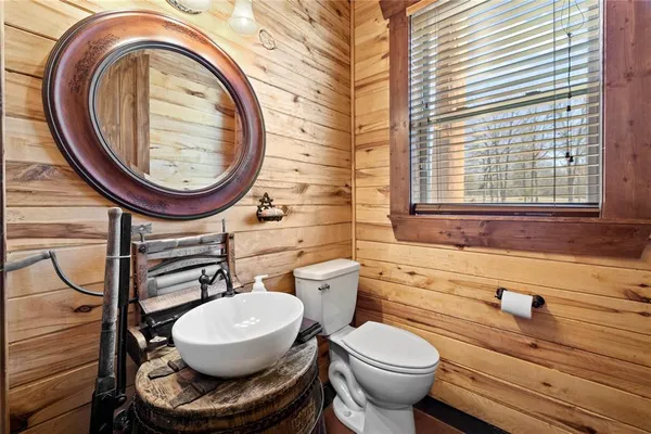 a bathroom with a granite countertop sink a toilet a mirror and shower