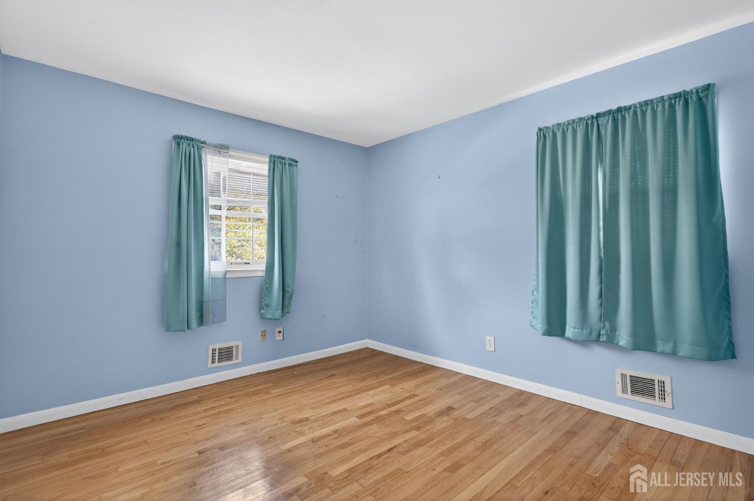 24 Moryan Road Edison, NJ 08817 - Photo 10 of 33 an empty room with wooden floor and windows